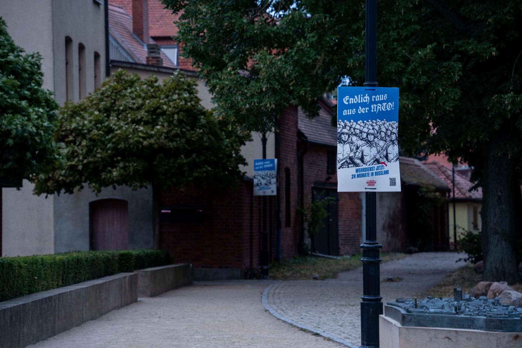 Plakat „Endlich raus aus der NATO! Wehrdienst jetzt: 24 Monate in Russland“ an einer Laterne